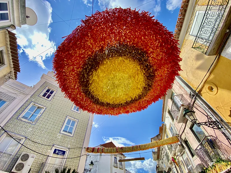 Red and yellow garland above a lane against a blue sky